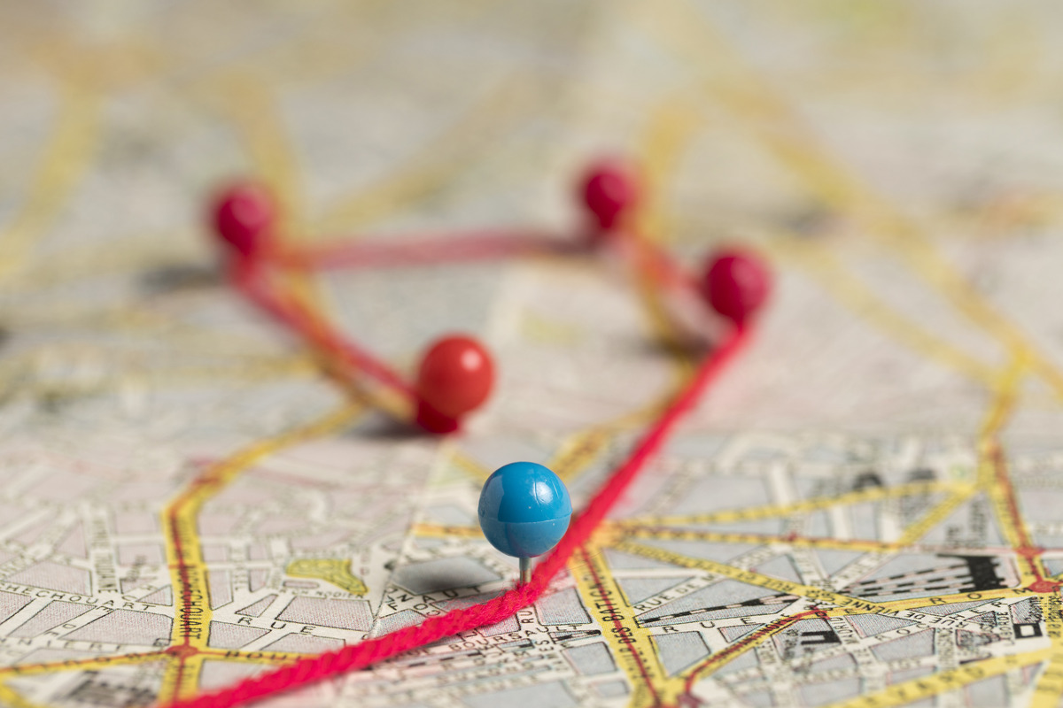 Pins-In-Map-Connected-By-A-Thread Different colored pins on a map connected with a thread to show relationship between the locations