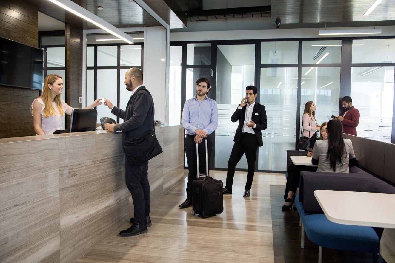 Guests waiting in line to be checked in at a hotel reception
