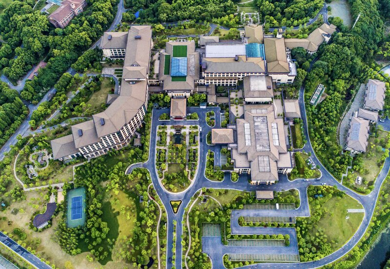 Arial view of a large hotel with beautiful grounds and internal roads