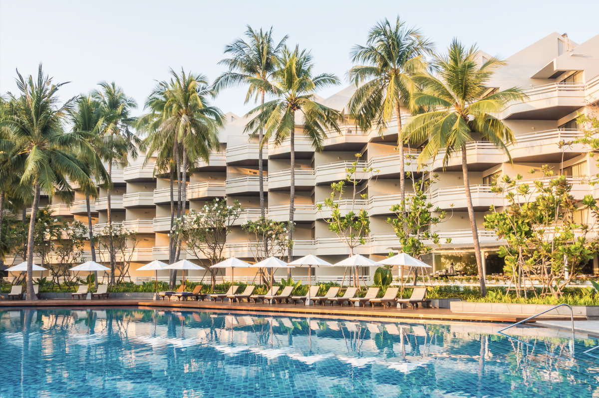 Photo of the impressive exterior of a hotel and its swimming pool, used in an article on hospitality tech
