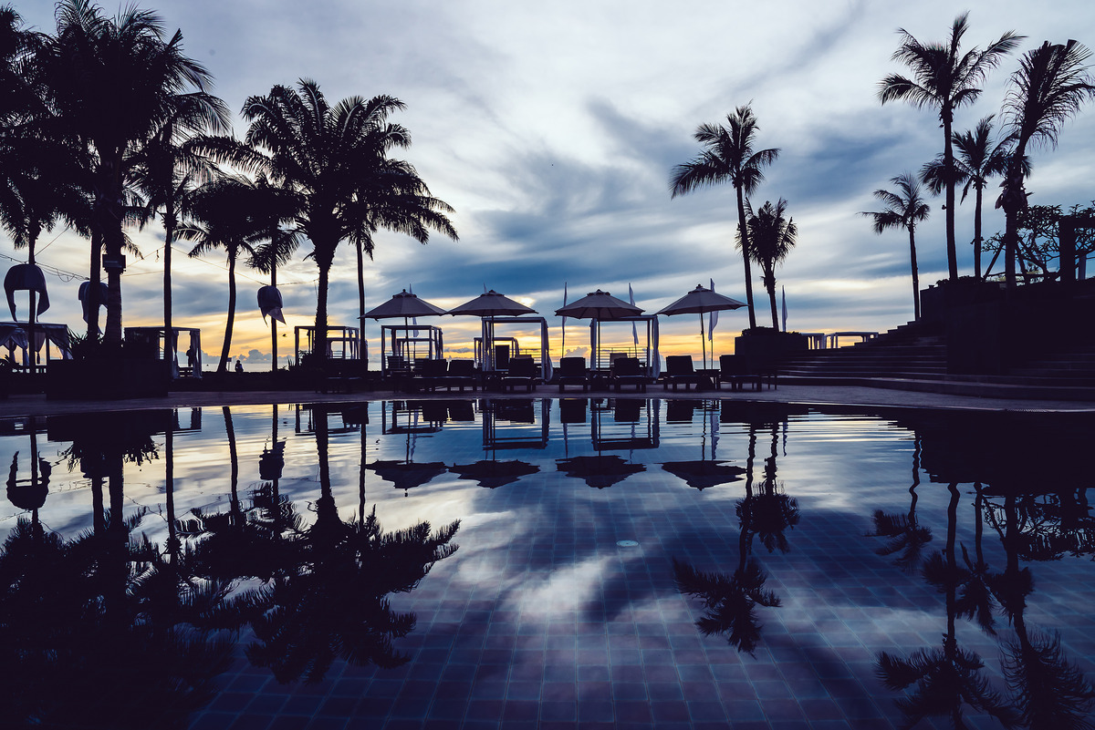 Photo of a beautiful evening seen at a hotel pool with lounge chairs and umbrellas, used in an article on hospitality tech