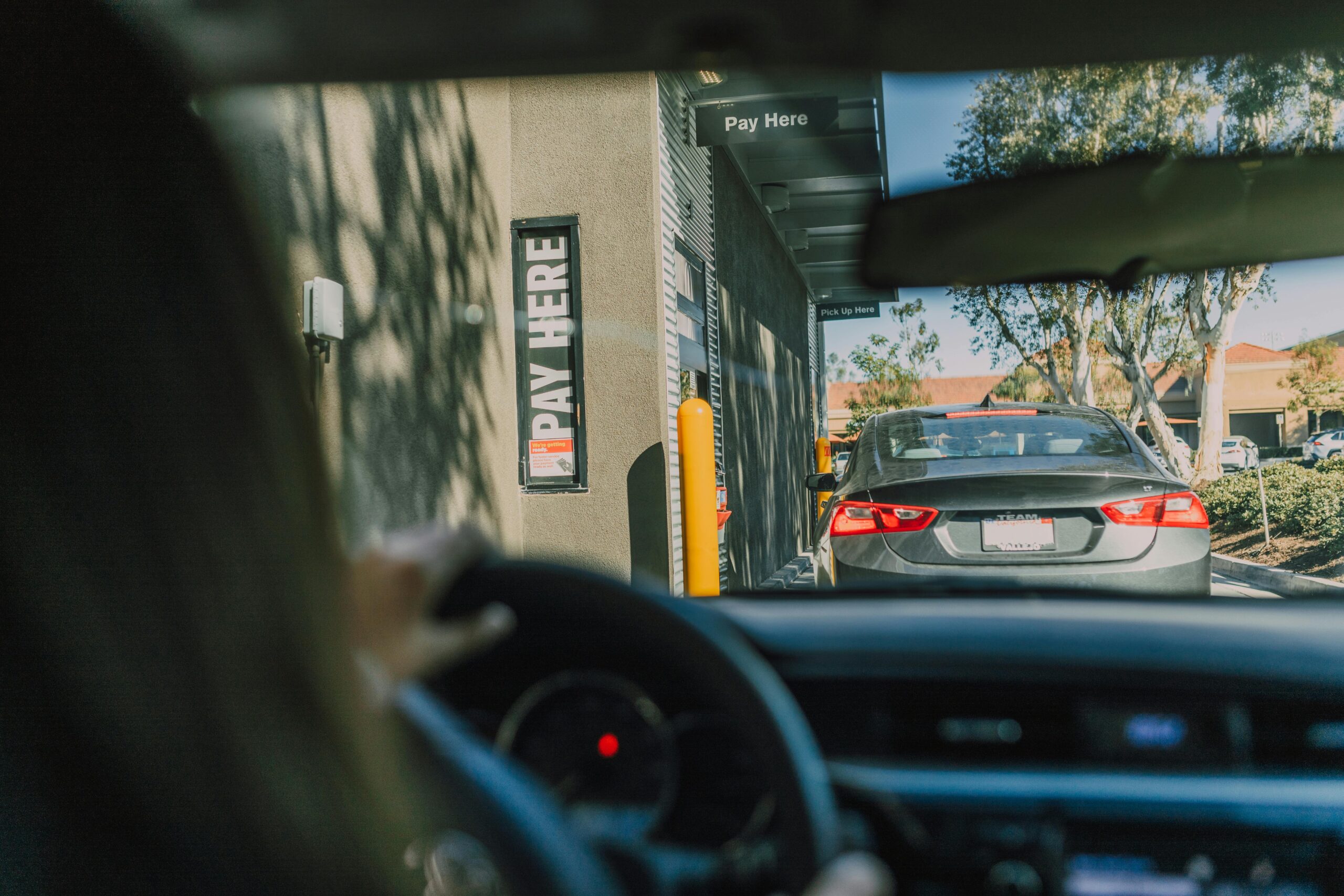 Drive through customer waiting in line A drive-through customer waiting in line in her car